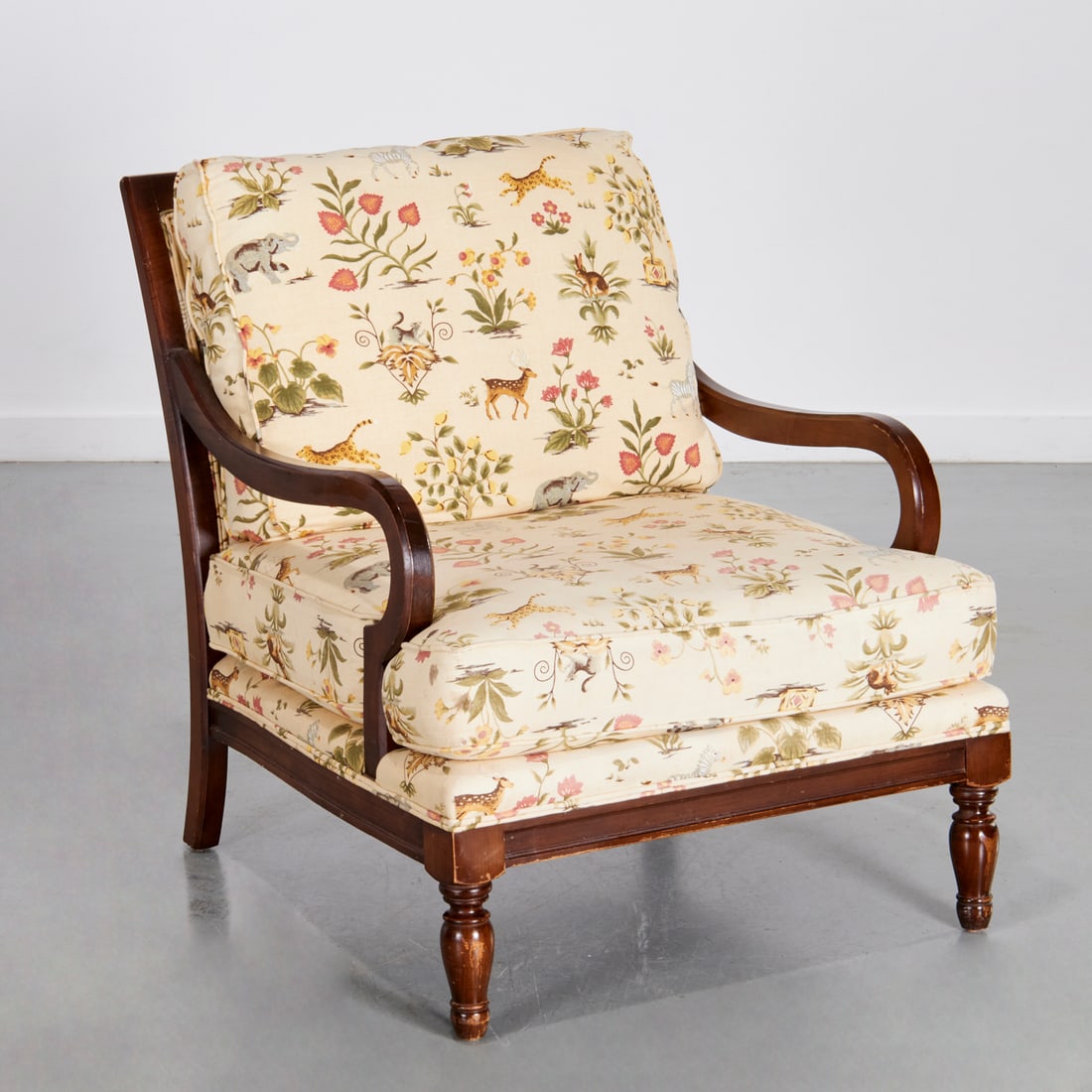 Miles Talbott, oversized upholstered armchair: Miles Talbott, oversized upholstered armchair, 20th c., mahogany frame with dramatic scrolled arms, upholstered in animal and topiary print fabric, in the style of Schumacher, label under seat cushion