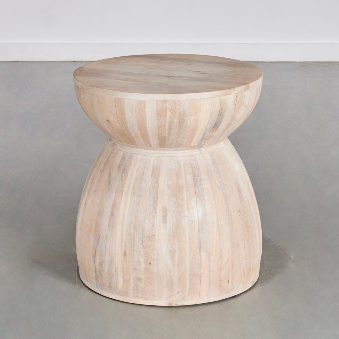 Anthropologie "Betania" side table: Anthropologie "Betania" side table, 21st c., hand carved tropical wood side table with bleached finish, 22.25"h x 19.75"dia Provenance: A Private Collection: 10 East 70th Street, NYC