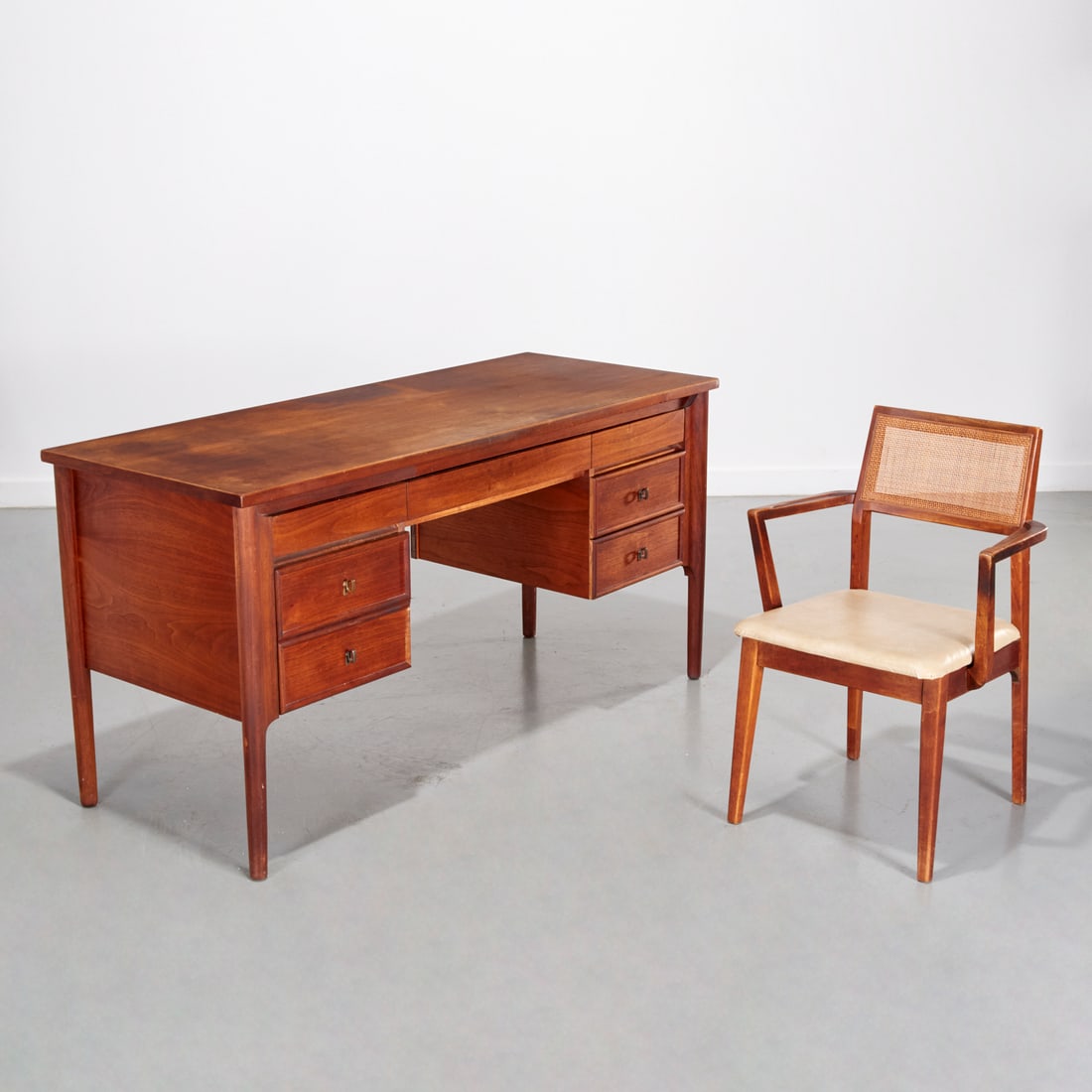 Ramseur Modernist desk and Scerbo chair: Ramseur Modernist desk and Scerbo chair, Mid-20th c., the desk marked "Ramseur Furn. Co.", and the armchair with caned back and vinyl seat, marked "F. Scerbo Art Studio", 30.5"h x 60.25"w x 24"d (desk