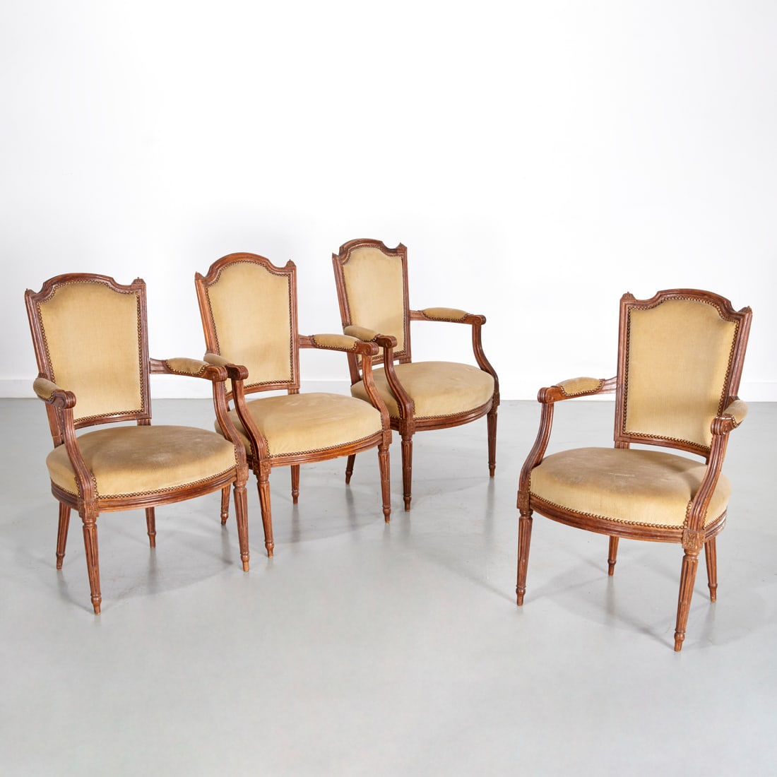 Set (4) Louis XVI style beechwood fauteuil: Set (4) Louis XVI style beechwood fauteuil, c. 19th c., France, channel carved front, the padded back, seat and armrests upholstered in an olive green striped velour, raised on round fluted legs, 36"h