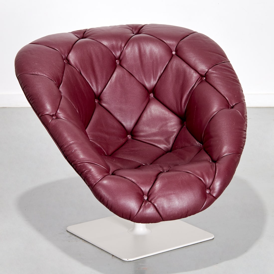 Moroso, "Bohemian" chaise longue: Moroso, "Bohemian" chaise longue, Designed 2008, by Patricia Urquiola, maroon button tufted leather, swivels on powder coated steel base, marked on underside of base, tag to leather cover, approx. 31.