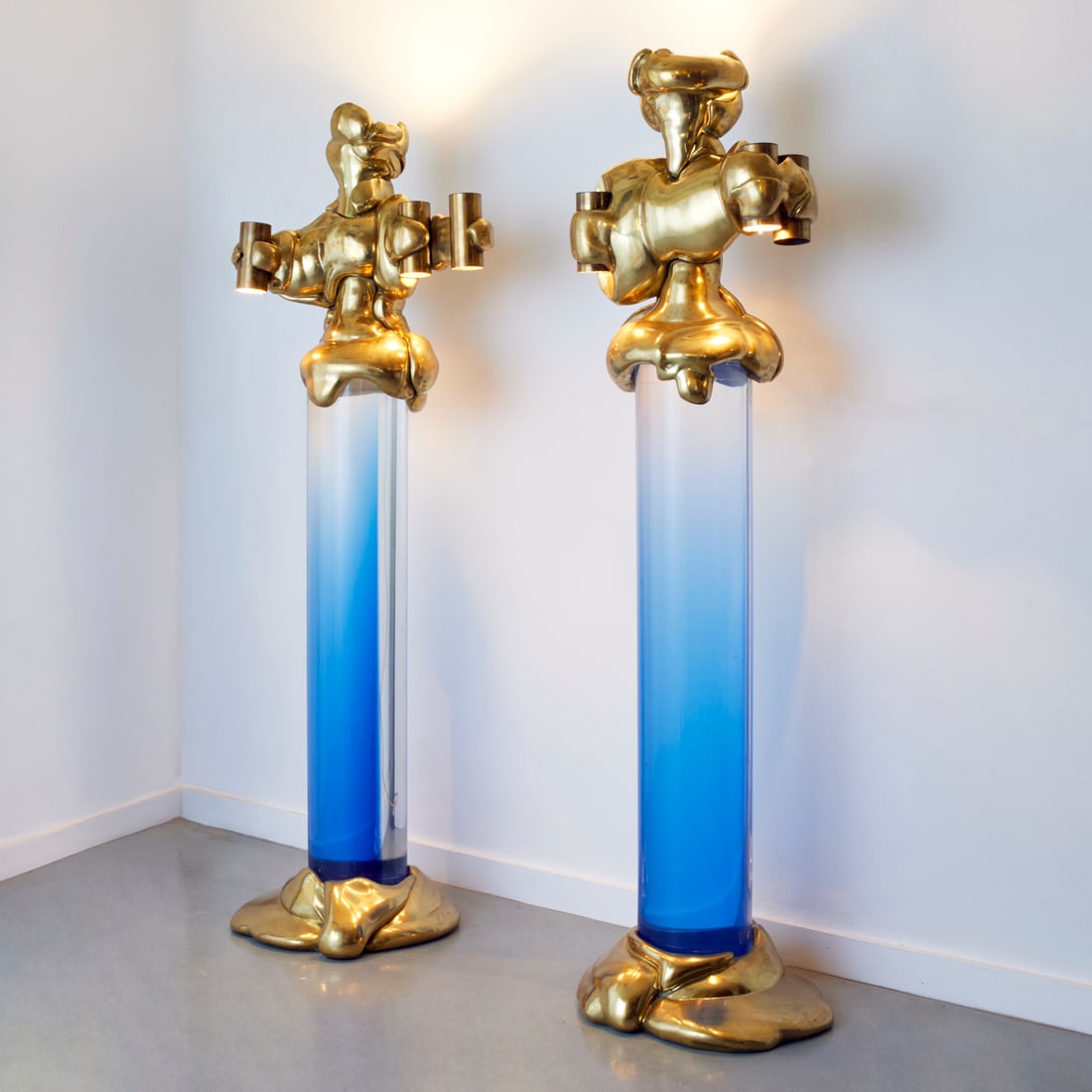 Cesar & Jean-Claude Farhi, illuminated columns: Cesar & Jean-Claude Farhi, illuminated columns, Cesar (French, 1921-1998) and Jean-Claude Farhi (French, 1940-2012), gilded bronze figural tops, blue gradient lucite, 1970, each signed "Cesar", stampe