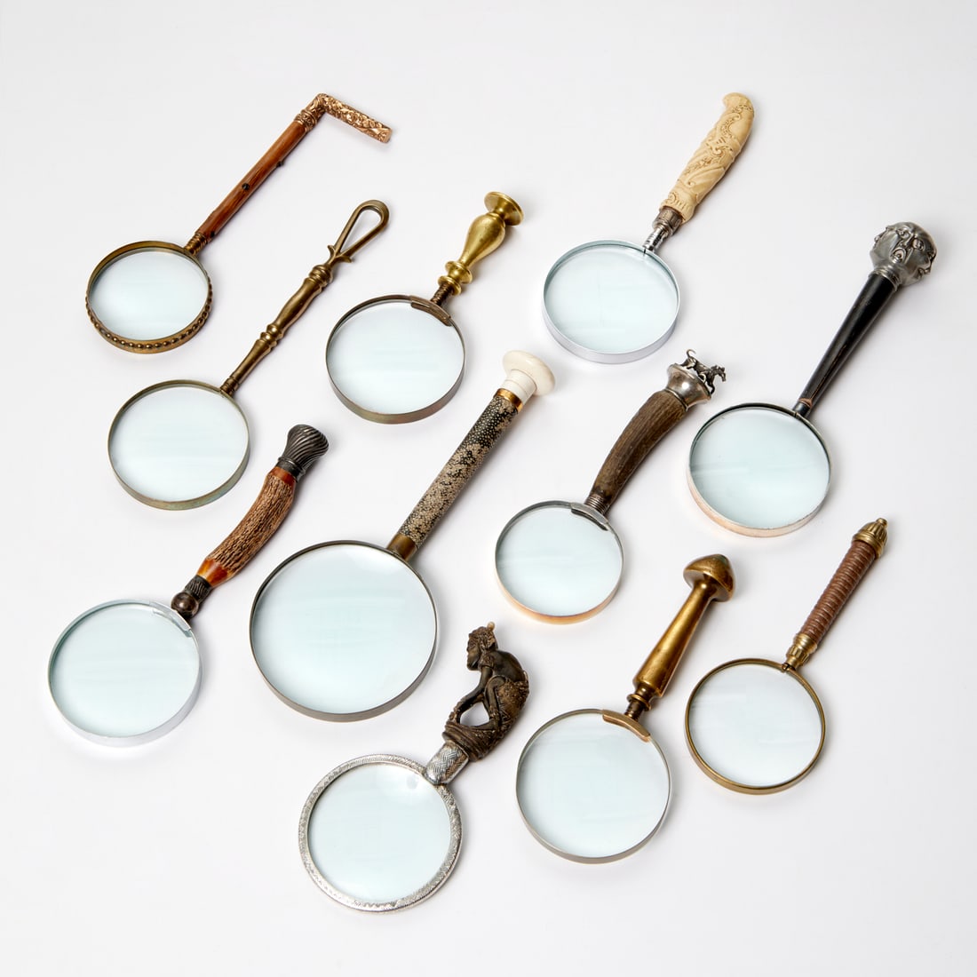 Nice collection antique magnifying glasses: Nice collection antique magnifying glasses, 19th/20th c., (11) pieces, handle materials include wood, antler, brass, silver, and bone,12"l x 5"w (largest), 8.5"l x 4.25"w (smallest) Provenance: A Priv