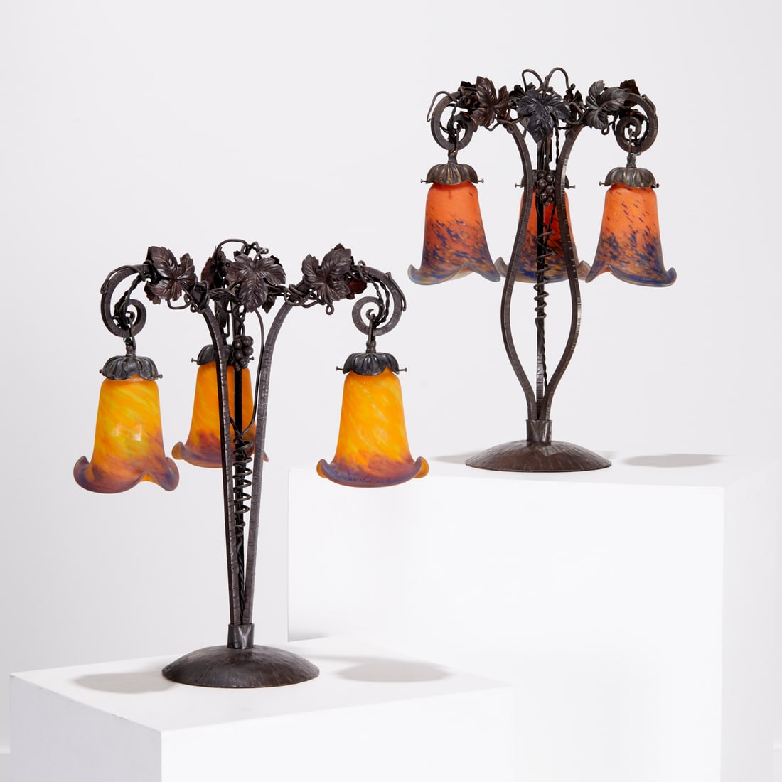 Pair Le Verre Francais table lamps: Pair Le Verre Francais table lamps, c. 1940s, France, grape vine form wrought iron base, patinated brass shade holders, multicolor glass shades, one in yellow tone, the other orange, each shade etched