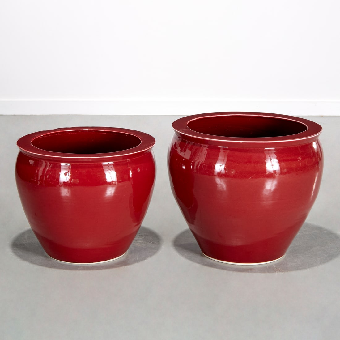 (2) Chinese Sang de Boeuf porcelain jardinieres: (2) Chinese Sang de Boeuf porcelain jardinieres, 20th c., unmarked, 19.75"h x 21.75"dia (larger), 17.25"h x 20.75"dia (smaller) Provenance: The Collection of Placido Domingo