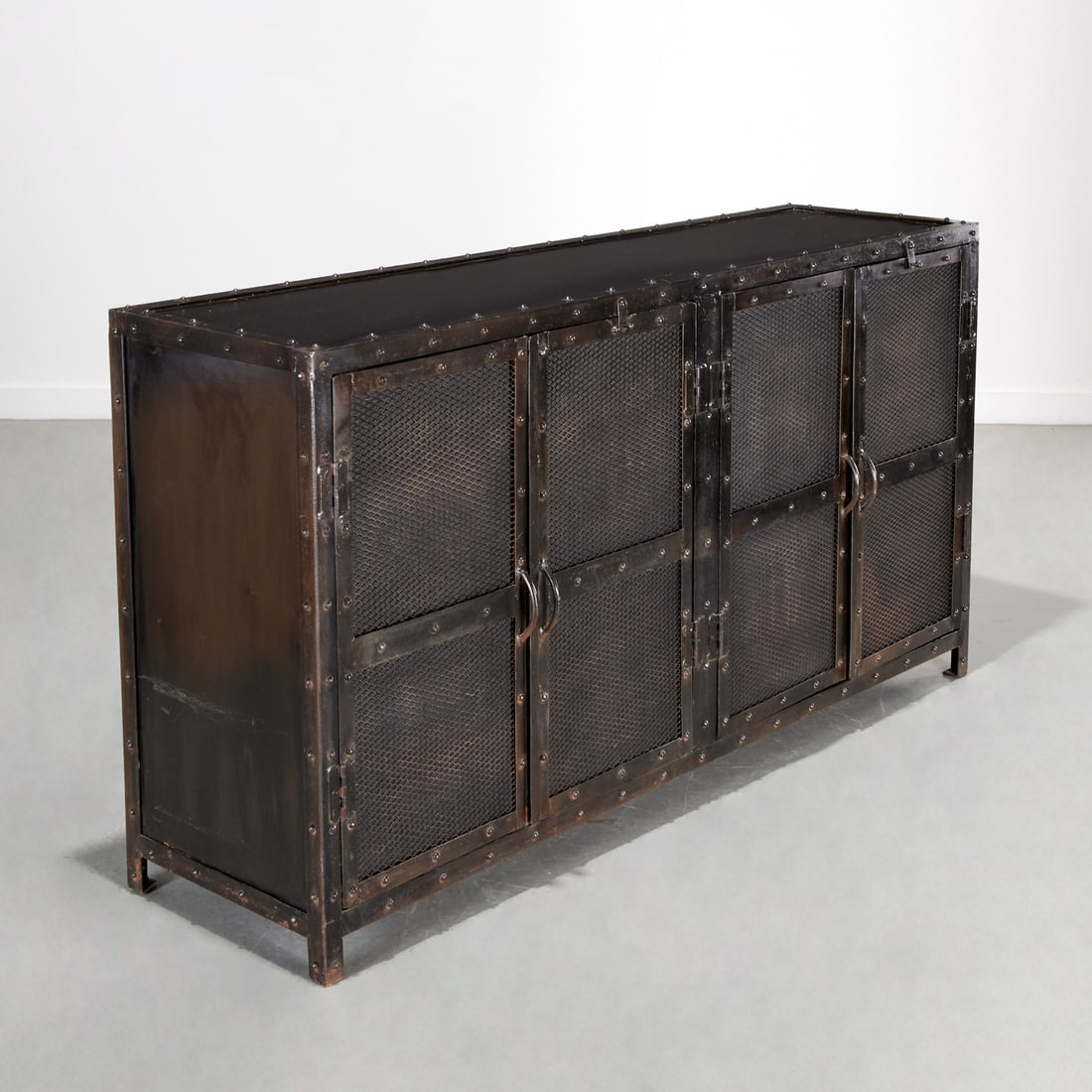 Industrial style patinated metal media cabinet: Industrial style patinated metal media cabinet, 21st c., with mesh lined wire cabinet doors, wire cutouts to back, unmarked, 35.5"h x 67"w x 17.75"d Provenance: A Private Collection: 1150 Park Avenue,