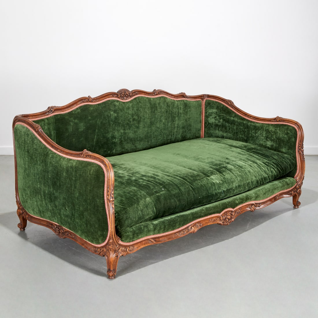 Antique Louis XV style carved, upholstered canape: Antique Louis XV style carved, upholstered canape, 19th/20th c., floral carved frame, dark green velvet upholstery, oversized with particularly deep single cushion seat, "Camard, Made in France" stick