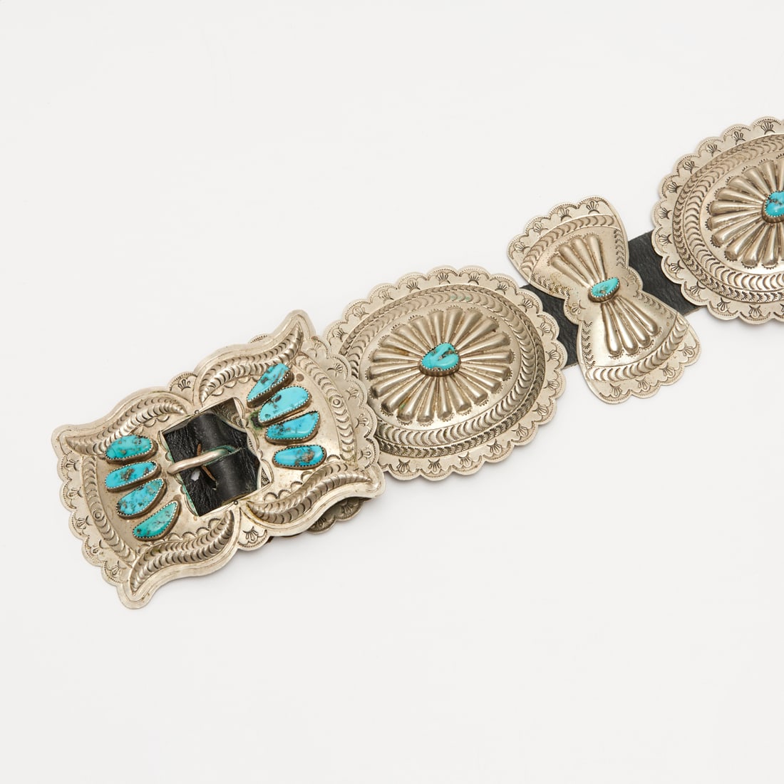 Navajo silver and turquoise concho belt: Navajo silver and turquoise concho belt, 20th c., American Southwest, repousse silver conchos with turquoise cabochons, butterfly buckle, unmarked, silver content unknown, incl. inventory tag, 44"l Pr