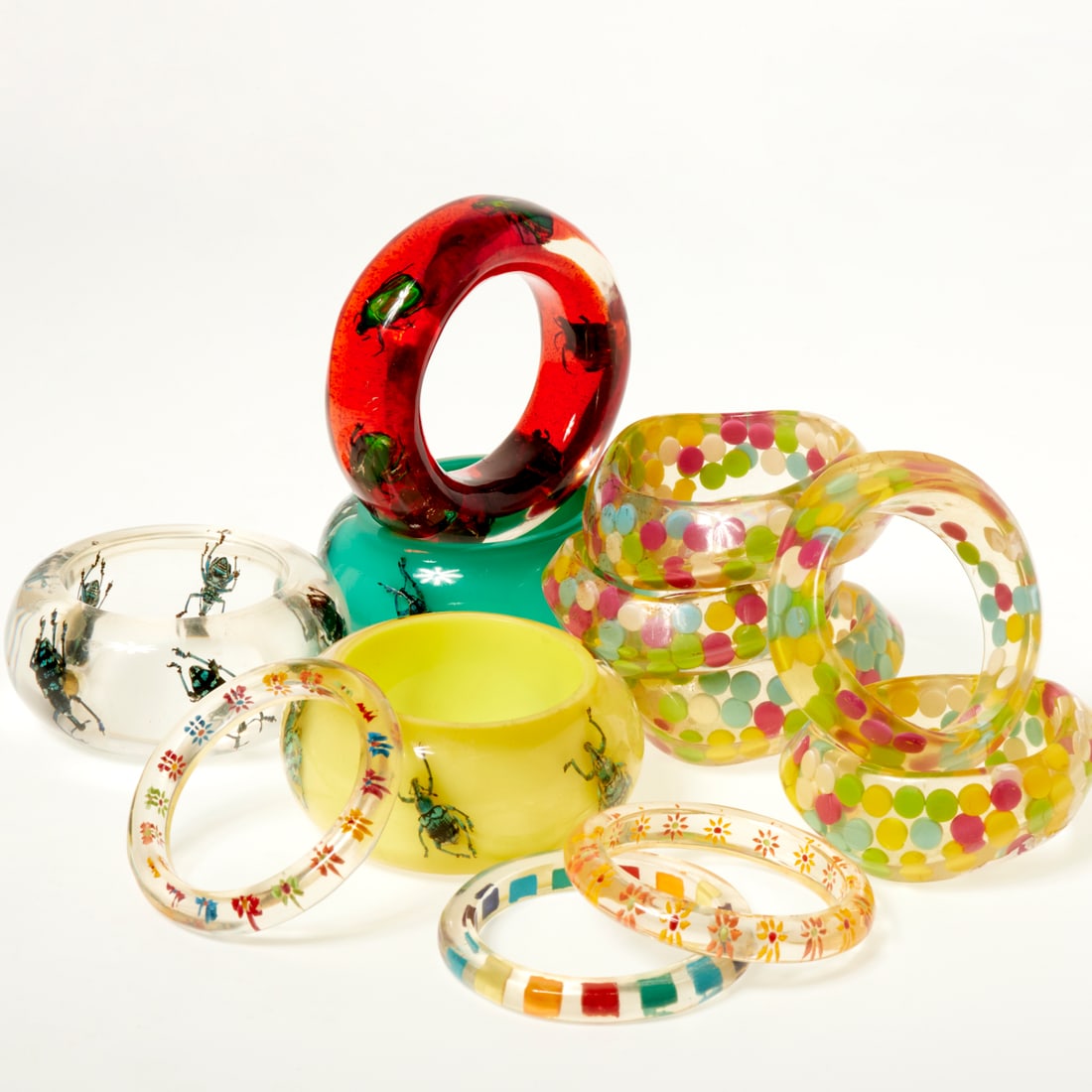 Selection of multicolor lucite bangles: Selection of multicolor lucite bangles, 21st c., including (4) insect examples from Kolos Studios and (5) dots, (3) thinner style with flowers and multicolor Provenance: The Iris Apfel Collection