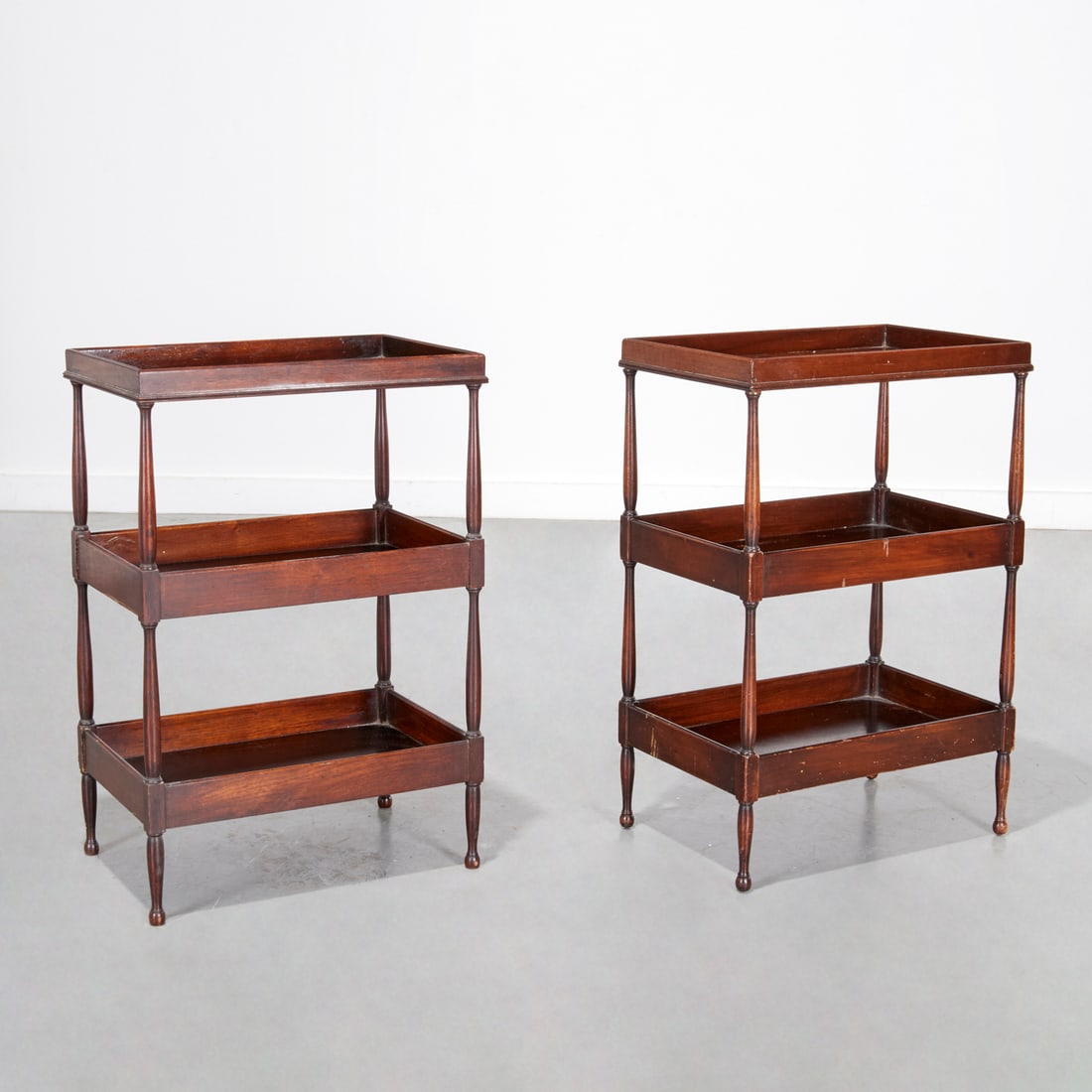 Pair Schmieg & Kotzian mahogany etagere tables: Pair Schmieg & Kotzian mahogany etagere tables, 20th c., in three galleried tiers, raised on tapered legs, one marked "SHK" (Schmieg, Hungate & Kotzian) underside, each 27"h x 18"w x 12"d Provenance: