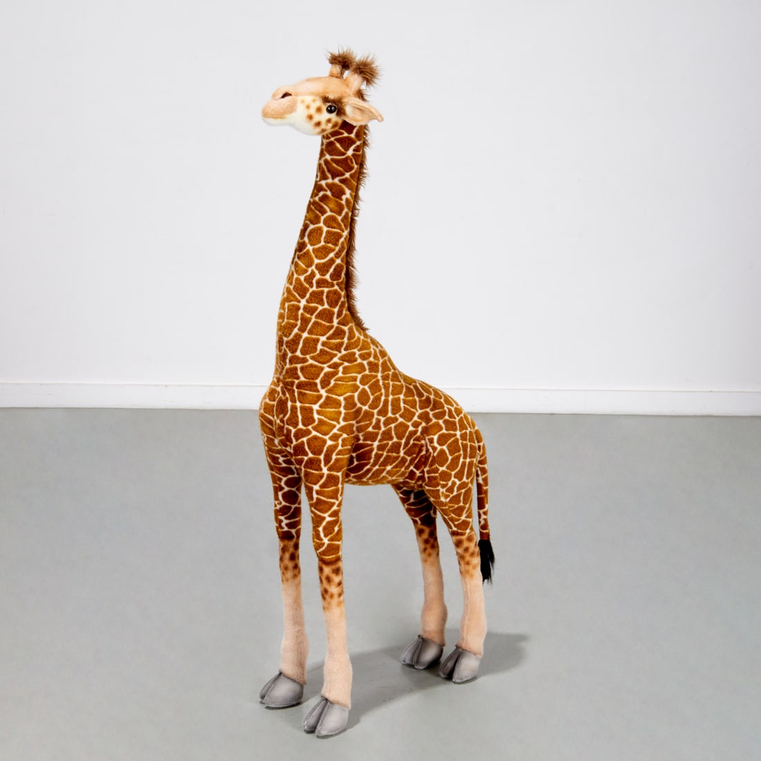 Large Hansa standing plush giraffe: Large Hansa standing plush giraffe, 20th c., brown plastic eyes, unjointed brown and white plush body, label to rear, 52"h x 26"l x 9"w Provenance: The Iris Apfel Collection