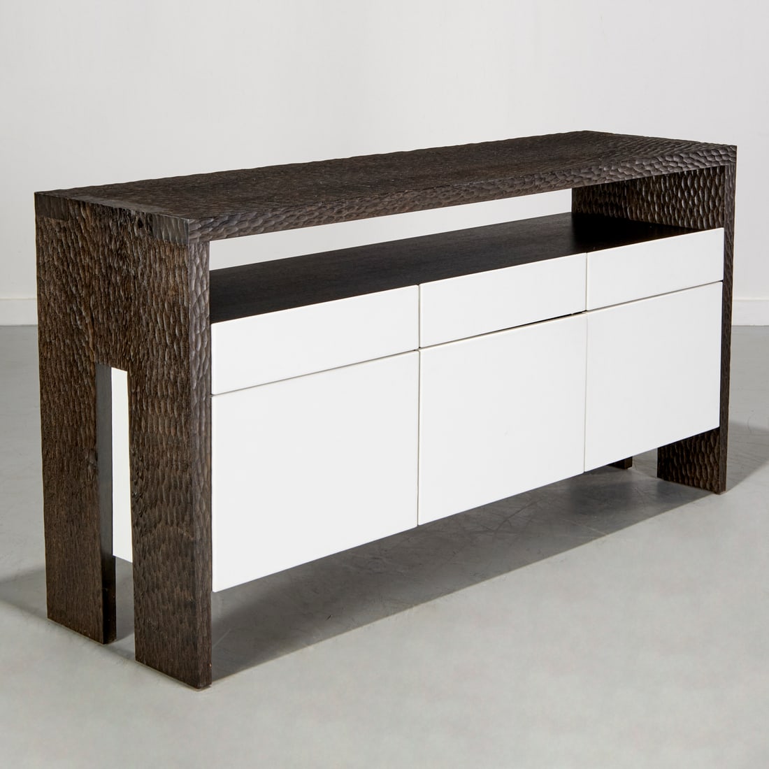 Philippe Hurel, "Rouvre" sideboard: Philippe Hurel, "Rouvre" sideboard, Philippe Hurel (French, 1955-2022), carved textured wood top over open shelf and three drawers and three panel doors in faux white leather, drawers open to compartm