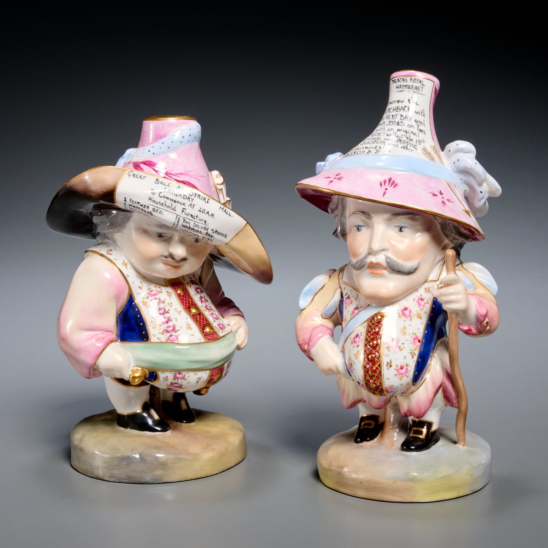 (2) Derby porcelain house dwarfs: (2) Derby porcelain house dwarfs, 20th c., England, pair of dwarf figures in traditional dress, theater and auction advertisements to hats, each marked underside, signed "J. Brown" underside, 7.25"h x