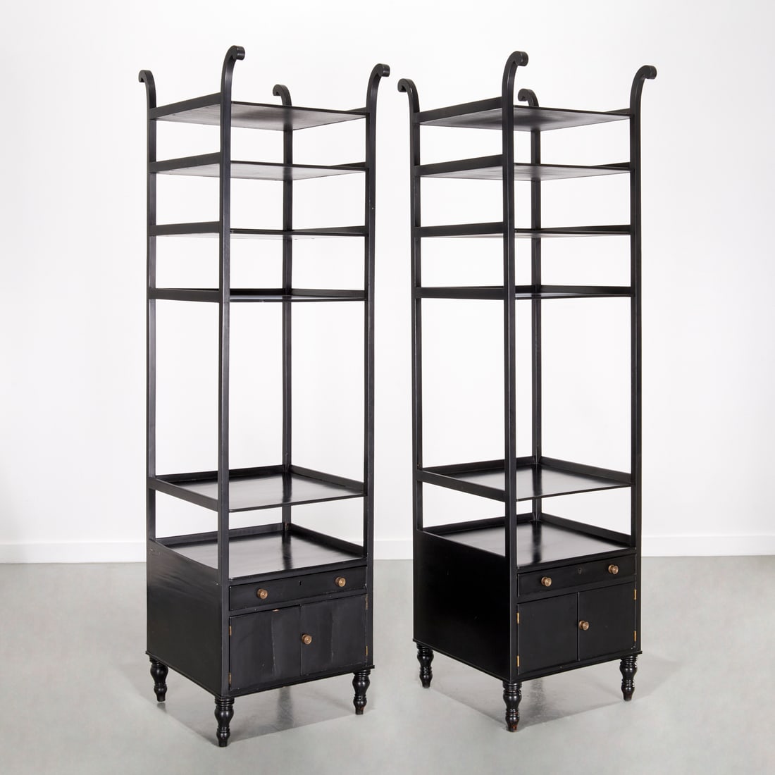 Nice pair Victorian black lacquer etageres: Nice pair Victorian black lacquer etageres, Late 19th/20th c., with scrolled stile finial and six open shelves over one drawer and cupboard doors on turned feet, unmarked, each 80"h x 21"squ Provenanc