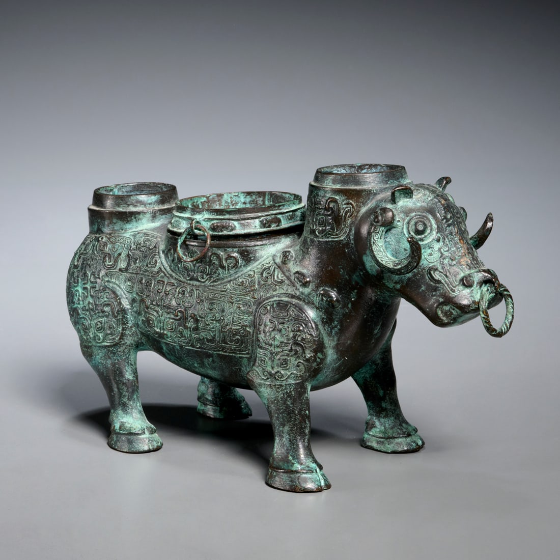 Chinese bronze ox-form zun: Chinese bronze ox-form zun, Spring and Autumn period style (approx. 770-476 BCE), ox-form wine vessel and warmer, with removable pot to center, body of ox decorated with taotie motifs, unmarked, 5"h x