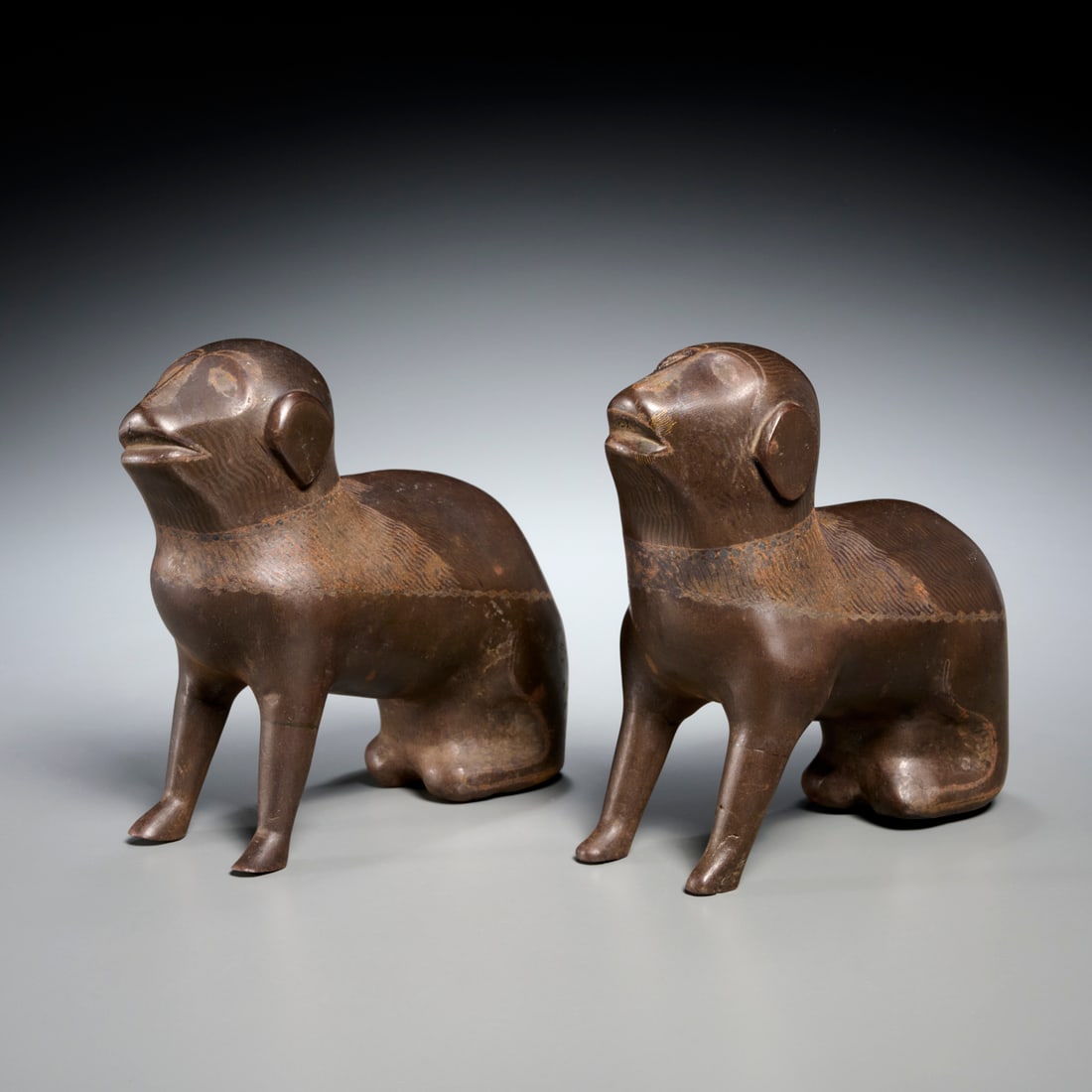 Pair Persian patinated metal hounds, ex Sonnenberg: Pair Persian patinated metal hounds, ex Sonnenberg, 19th c., Qajar Period, Seated Hounds, with remnant silvered decoration, unmarked, each 7.5"h x 7"l x 3.5"d Provenance: A Private Collection: 870 Uni