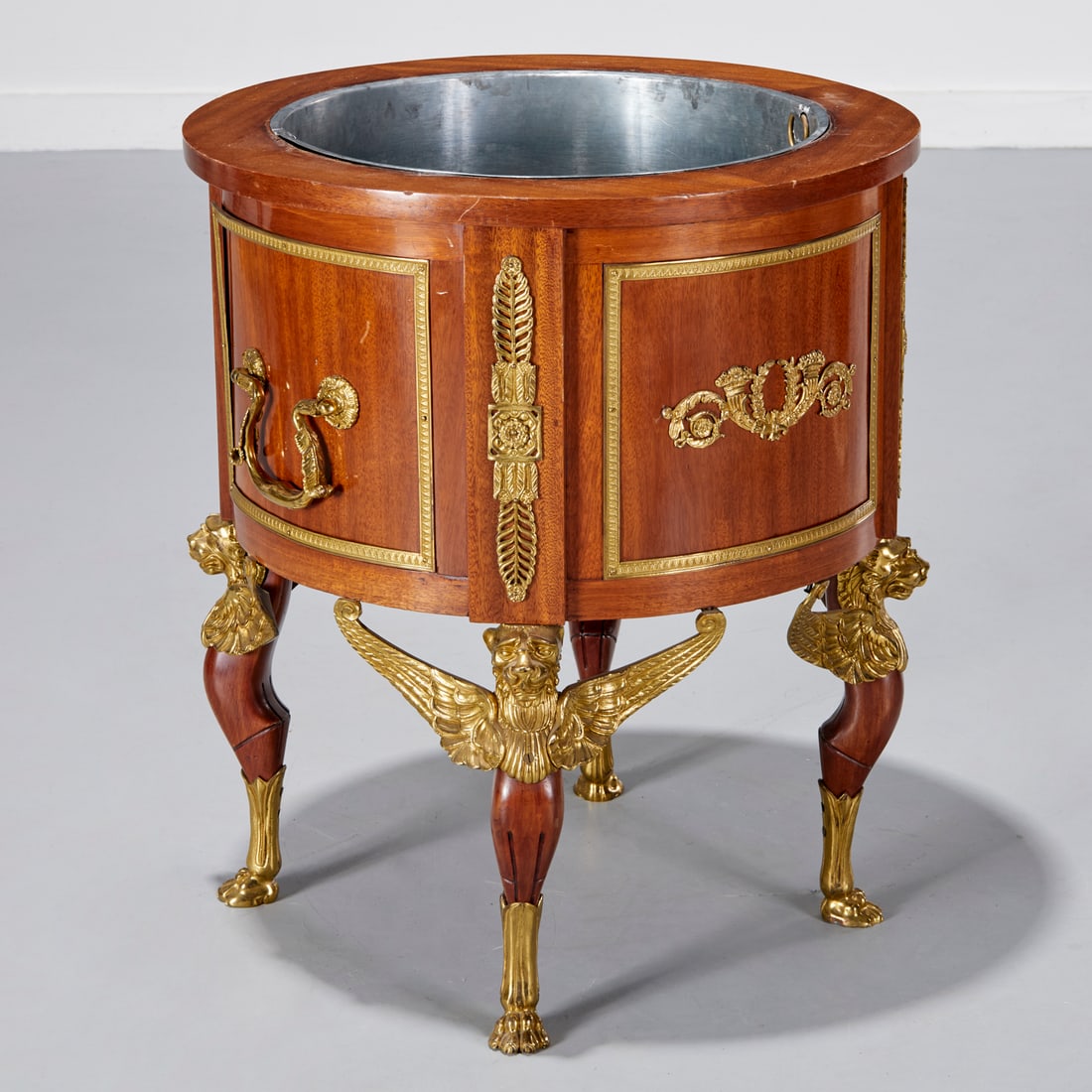 Empire Revival gilt metal mounted jardiniere: Empire Revival gilt metal mounted jardiniere, Late 19th/20th c., metal liner, scroll and rosette pulls, acanthus mounts, raised on griffin legs, unmarked, 25.75"h x 22"dia Provenance: A Private Collec