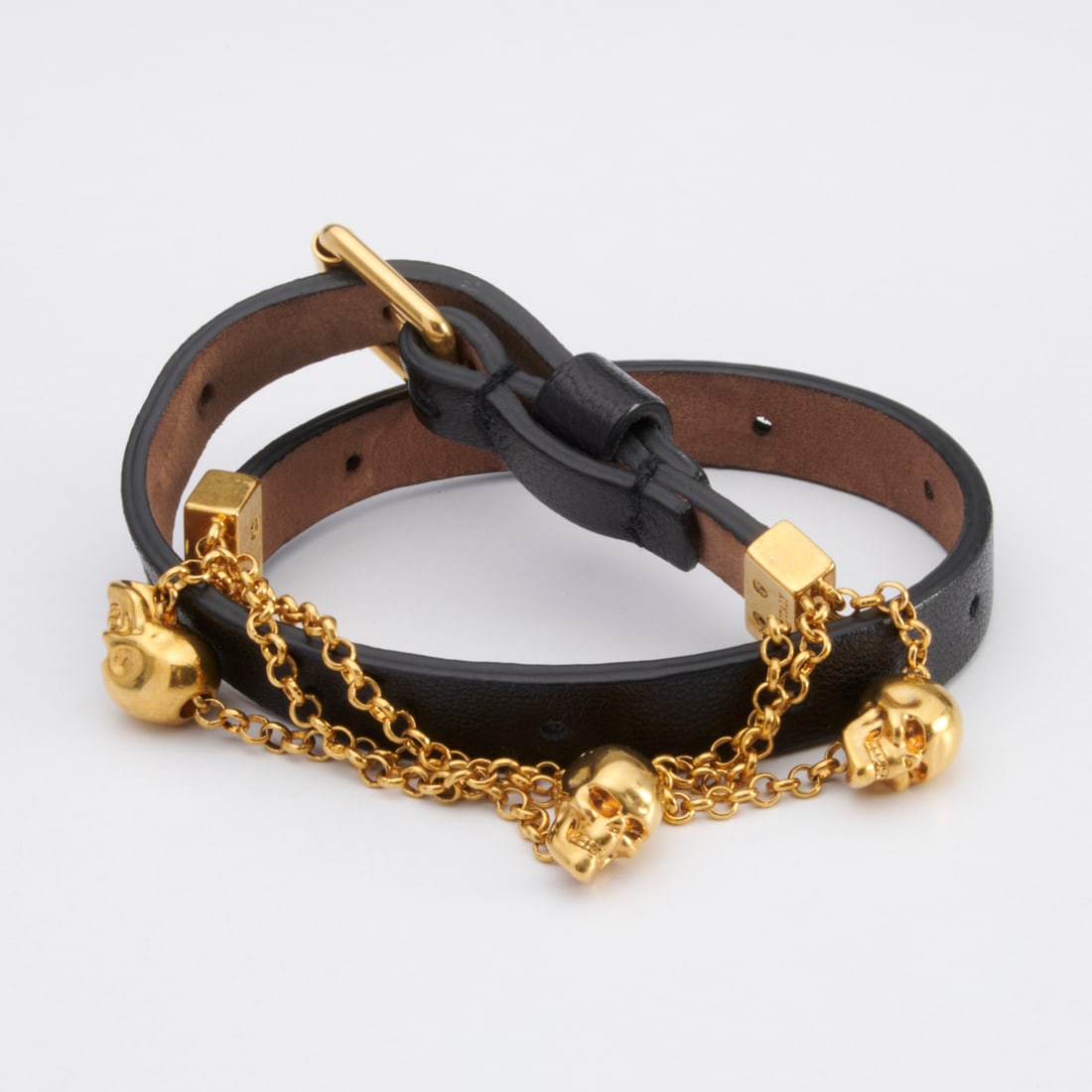 Alexander McQueen skull double wrap bracelet: Alexander McQueen skull double wrap bracelet, 21st c., Made in Italy, in black leather with gold-tone metal, 15.75"l (end to end), with Q stamp Provenance: From the Personal Collection of a Saks Fifth