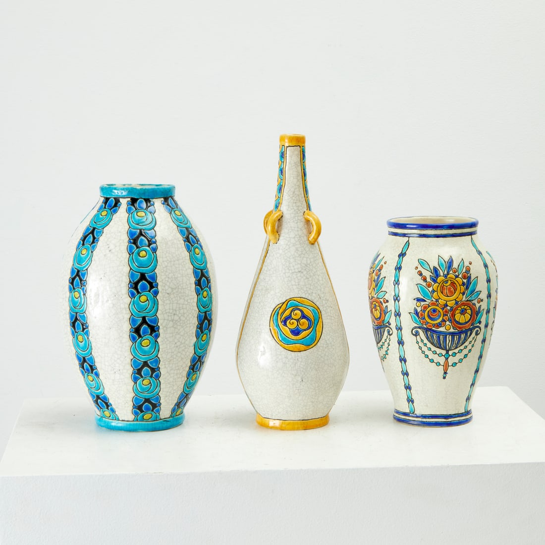 Charles Catteau for Boch Freres, (3) pottery vases: Charles Catteau for Boch Freres, (3) pottery vases, c. 1920s-1930s, Belgium, floral decoration on crackle glaze, marked on undersides, with collection numbers, 13"h x 5"w (largest), 9.25"h x 6"w (smal