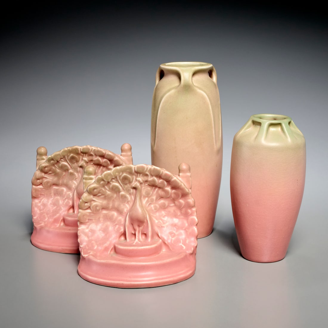 Rookwood pottery group: Rookwood pottery group, c. 1920-1927, USA, incl. (2) pink matte glazed vases, #2126 and #2329, and a pair of pink peacock bookends, #2445, each with maker's mark to underside, with collection number,