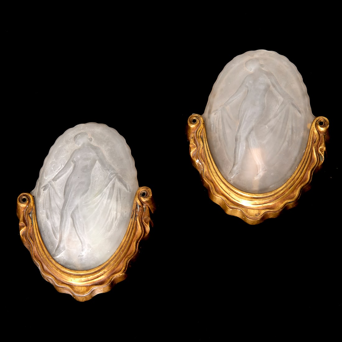 Pair Muller Freres "Nymphs" wall sconces: Pair Muller Freres "Nymphs" wall sconces, c. 1925, Luneville, each oval molded glass panel decorated with a nude beauty in low relief, signed on lower edge, in gilt metal drapery-cast frame, 11.5"h x