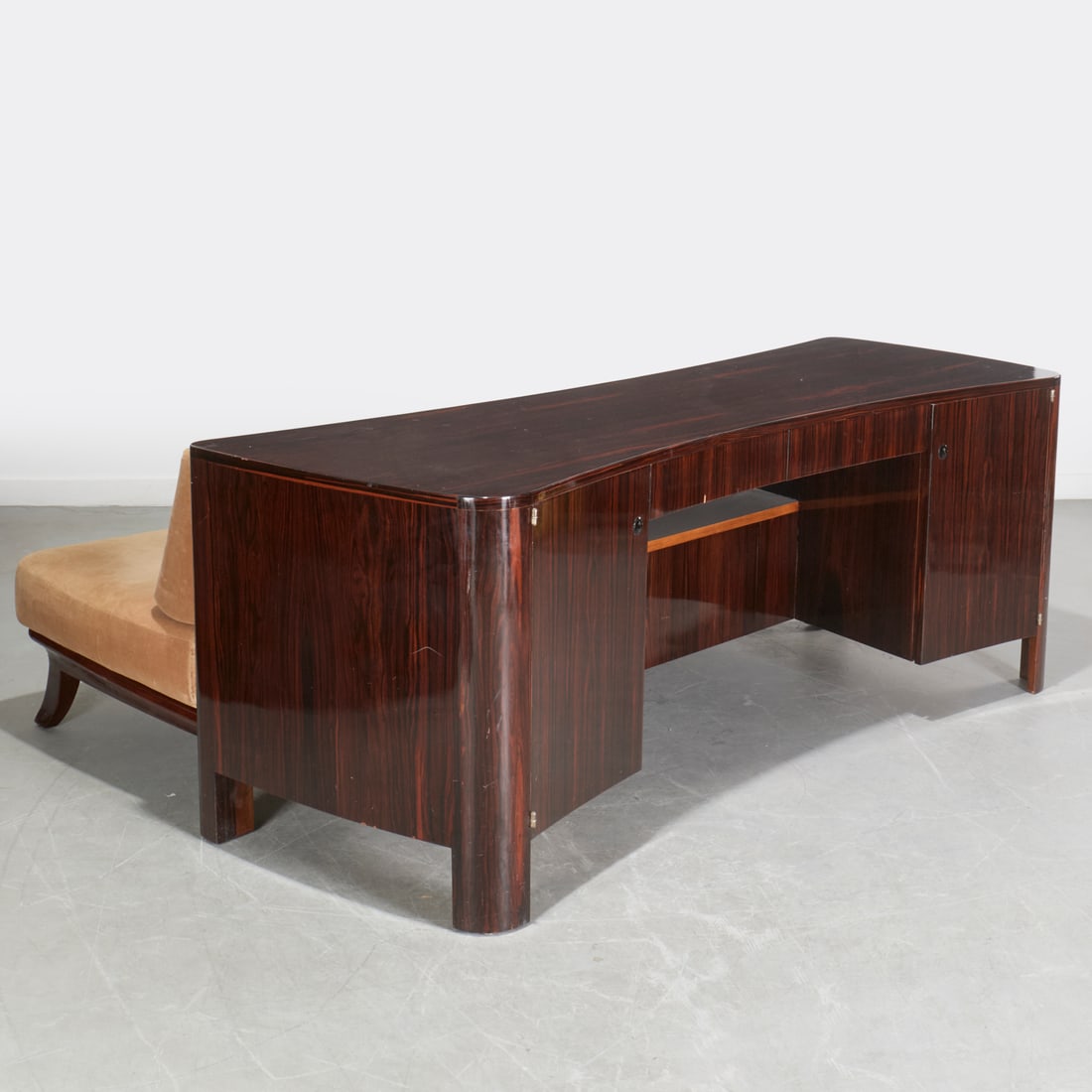 Unusual Art Deco macassar desk and sofa bed: Unusual Art Deco macassar desk and sofa bed, c. 1930s, France, curved top with rounded corners, frieze drawers over kneehole flanked by panel doors, attached daybed with loose seat cushions, unmarked,