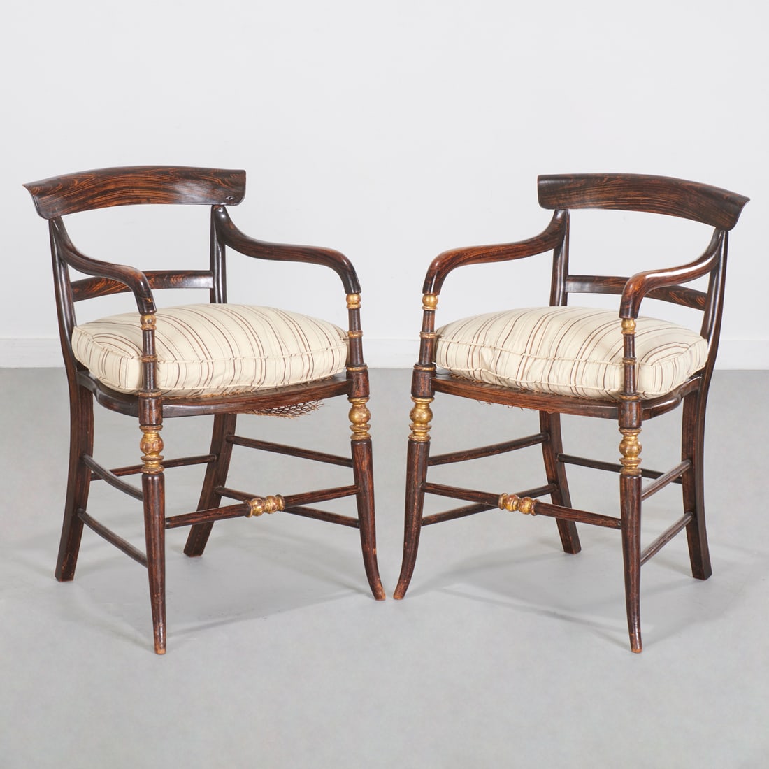 Pair Regency grain painted armchairs: Pair Regency grain painted armchairs, 19th c., rosewood finish frame with caned seats, on tapering legs, cream and mocha stripe upholstery to loose cushion, unmarked, each 32"h x 20.5"w x 21"d Provena