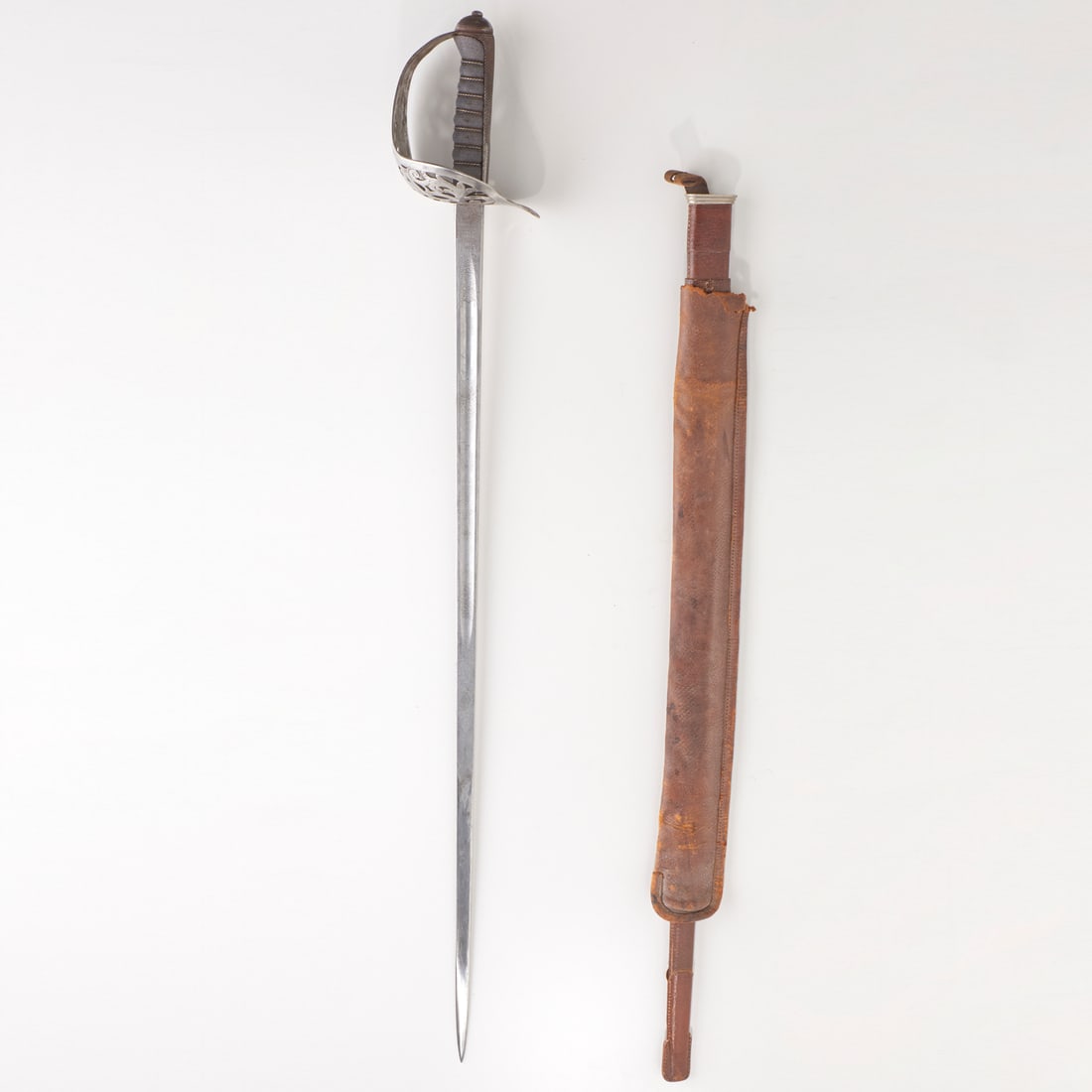 Henry Wilkinson Pall Mall London sword and sheath: Henry Wilkinson Pall Mall London sword and sheath, Mid-late 19th c., pierced guard, fish skin grip, etched blade with scrolls and British Royal Guard crest, Prince of Wales' feathers, and "by appointm