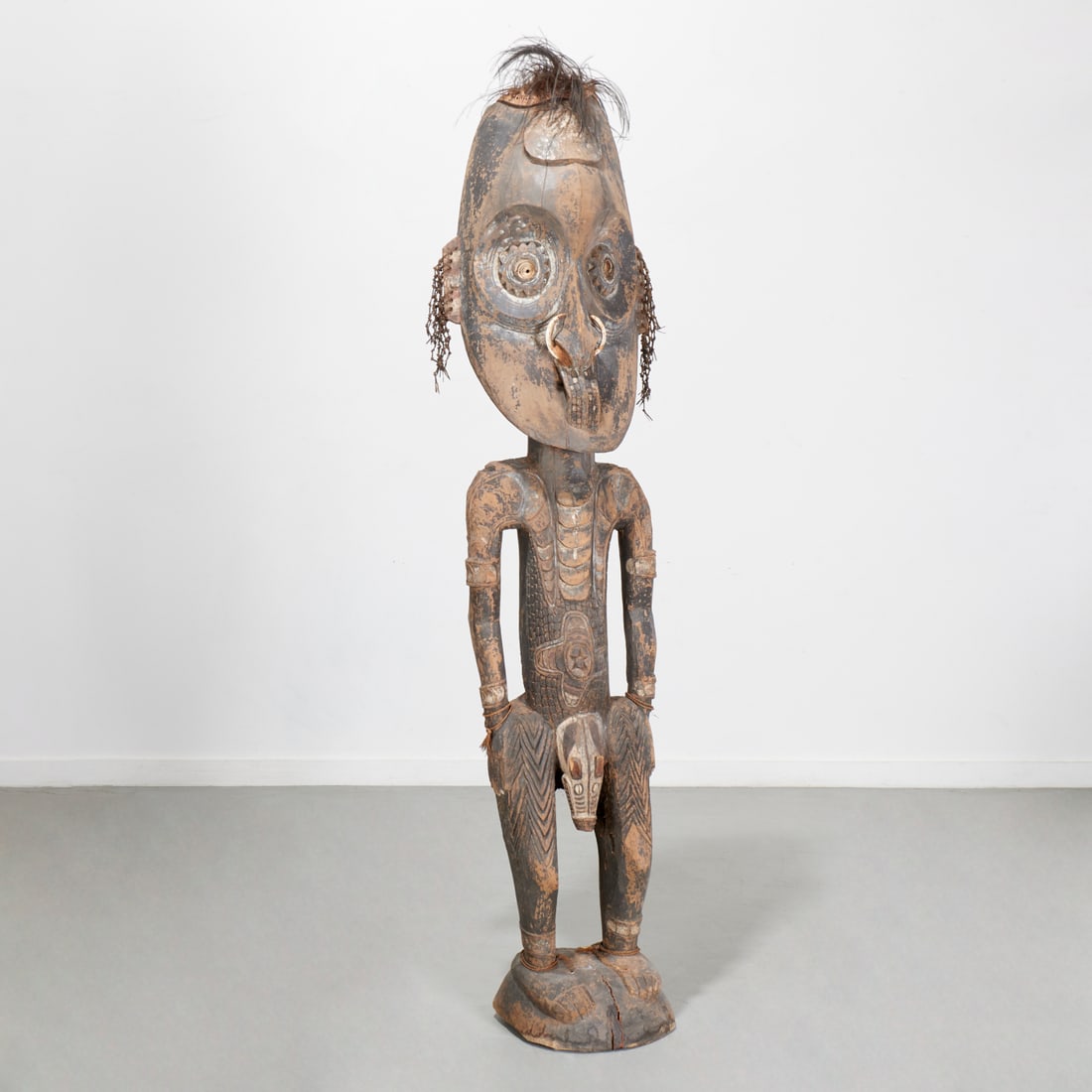 Large Sepik River carved wood figure: Large Sepik River carved wood figure, 20th c., Papua New Guinea, polychrome with horn, feather, braided grass, 81"h x 16"w x 11"d Provenance: A Private Collection: 22 Partridge Hill Lane, Greenwich, C