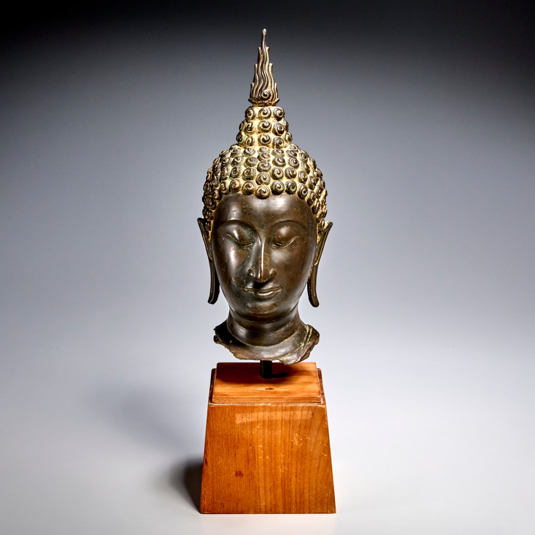 Antique Sukhothai style bronze Buddha head: Antique Sukhothai style bronze Buddha head, 18th/19th c., possibly earlier, Southeast Asia, in the classic 16th c. style, on custom stand, 13"h x 5.25"w x 6"d (bronze), 18.75"h (incl. base)