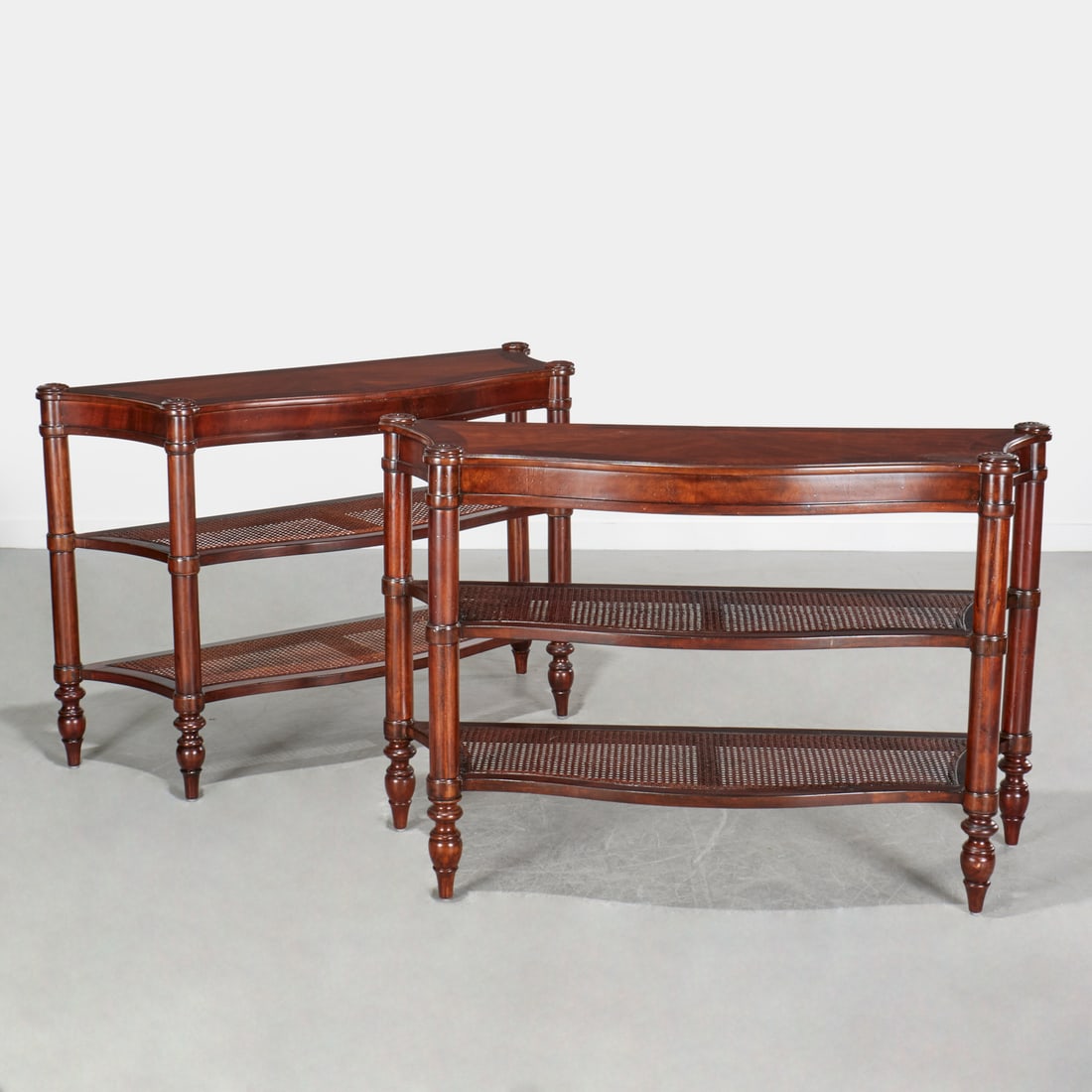 Pair Hekman Regency style caned console tables: Pair Hekman Regency style caned console tables, 21st c., USA, serpentine front, caned open tier shelves, raised on turned legs, label underside, each 34"h x 52"w x 17.5"d Provenance: A Private