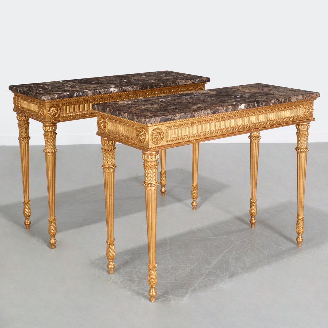 Pair George III style giltwood consoles: Pair George III style giltwood consoles, 20th c., nice quality, rectangular variegated marble top over carved frame with stop-fluted apron and rosette corners, raised on acanthus carved tapering