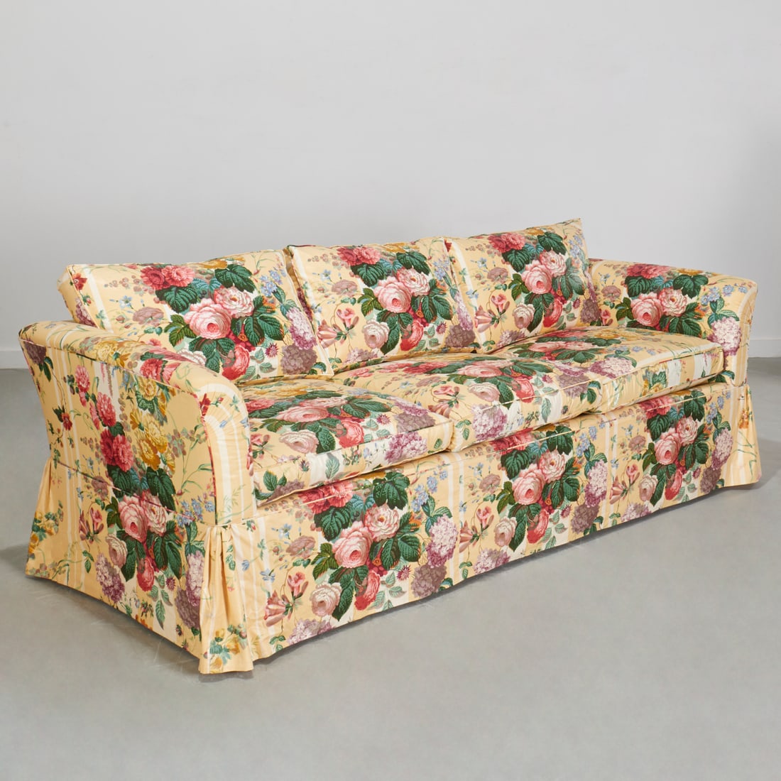 Thomas DeAngelis, NY, custom chintz sofa: Thomas DeAngelis, NY, custom chintz sofa, 20th c., upholstered in yellow Cabbage Rose, three seat loose cushions with skirted base, unmarked, 36"h x 87"w x 35"d Provenance: A Private Collection: 1095