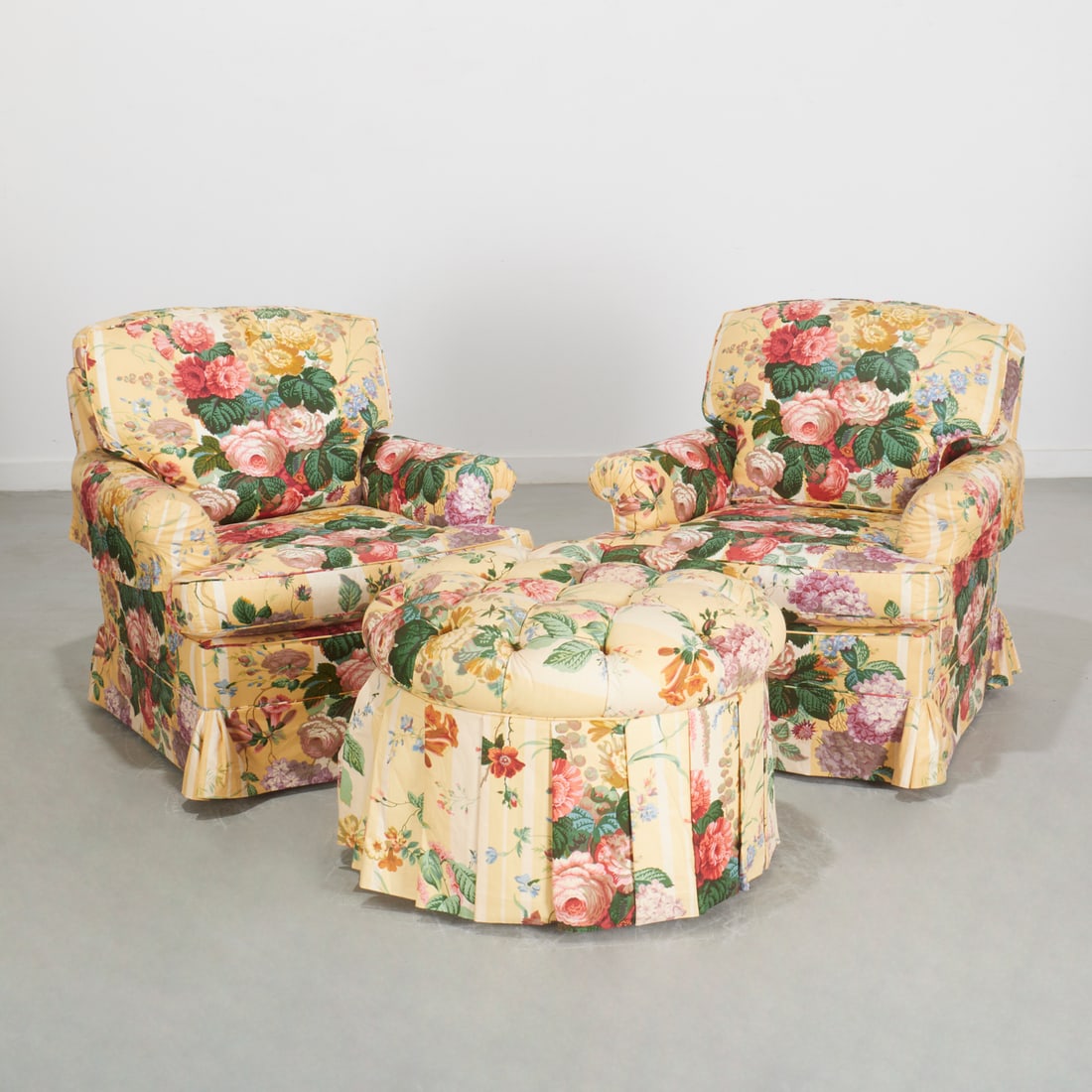 Thomas DeAngelis, NY, pair chintz lounge chairs: Thomas DeAngelis, NY, pair chintz lounge chairs, 20th c., (3) pieces, upholstered in yellow Cabbage Rose, loose cushion seating with skirted base; together with a matching round button tufted
