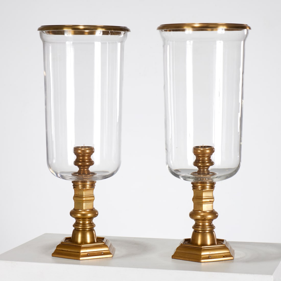 Pair Ralph Lauren brass mounted photophores: Pair Ralph Lauren brass mounted photophores, 20th c., in the Louis XIV style, brass mounted glass on pricket stand, placard label to base edge, each 20.75"h x 8.5"dia Provenance: A Private