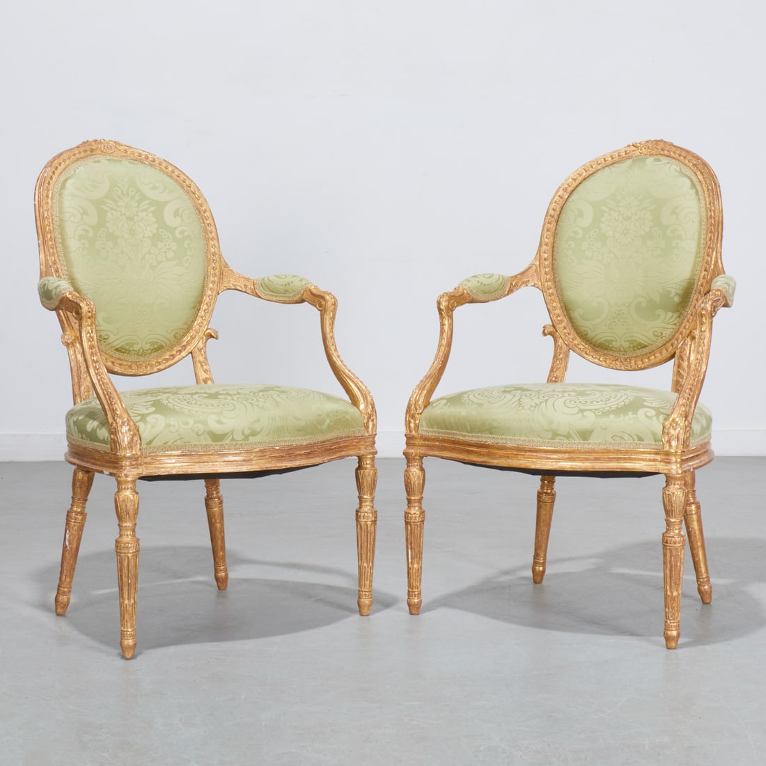John Linnell (attrib), pair George III armchairs: John Linnell (attrib), pair George III armchairs, c. 1780, England, attributed to John Linnell, carved and gilded frame, oval back with imbricating leaf decoration and rosette crest, padded armrests,