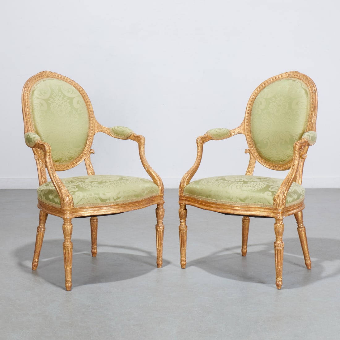 John Linnell (attrib), pair George III armchairs: John Linnell (attrib), pair George III armchairs, c. 1780, England, attributed to John Linnell, carved and gilded frame, oval back with imbricating leaf decoration and rosette crest, padded armrests,