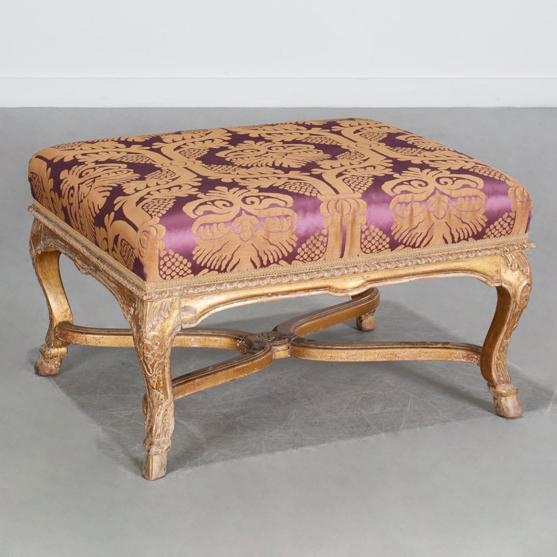 Antique Regence style giltwood tabouret: Antique Regence style giltwood tabouret, First half 20th c., purple and gold silk damask seat, on acanthus carved cabriole legs joined by cross stretcher, on hoof feet, unmarked, 17"h x 28"w x 23"d Pr