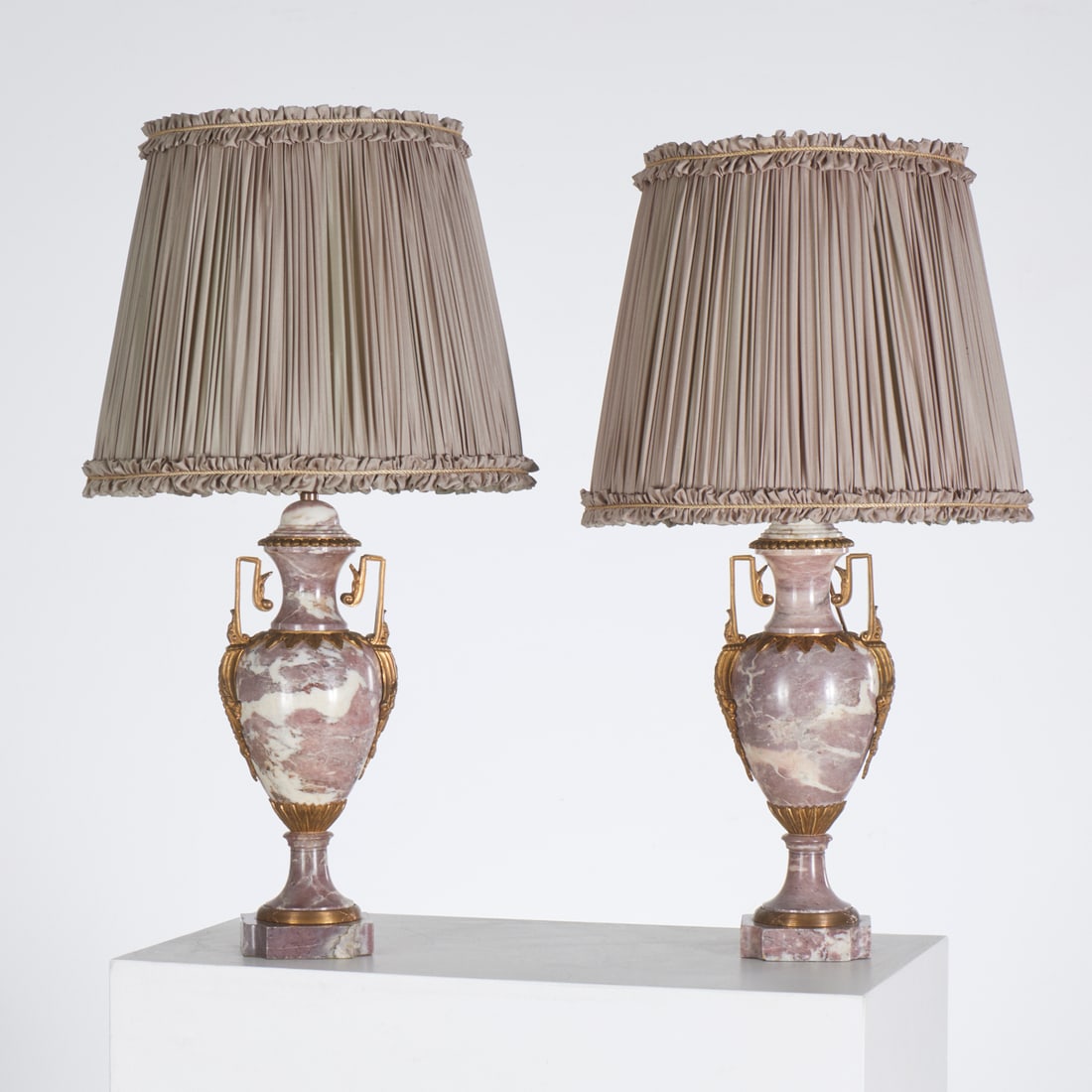 Pair Louis XVI style marble urn lamps: Pair Louis XVI style marble urn lamps, Late 19th/20th c., variegated liver marble with gilt bronze mounts, unmarked, "The Studio" label underside, 27"h x 5.5"dia (lamp only) Provenance: A Private