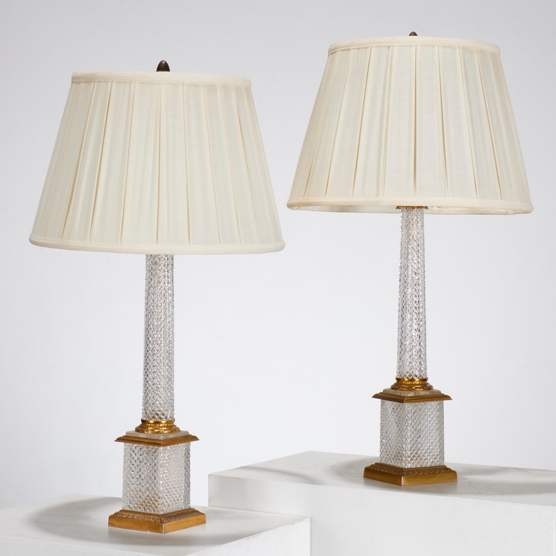 Pair Baccarat style ormolu mounted cut glass lamps: Pair Baccarat style ormolu mounted cut glass lamps, Mid 20th c., of tapering columnar form, with gilt metal fittings on square plinth, unmarked, each approx. 31"h x 4.25"squ Provenance: A Private