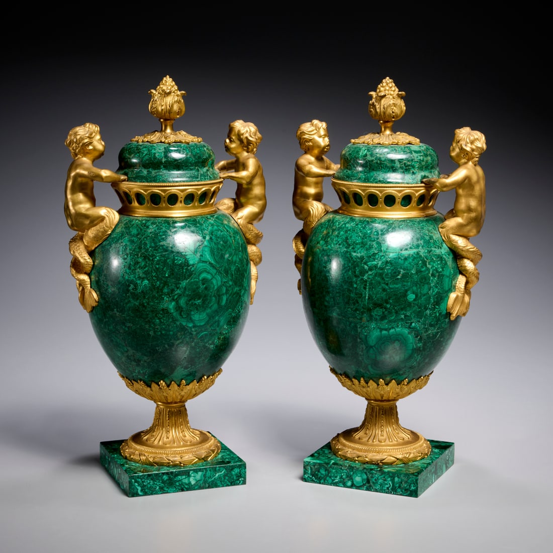 Pair Louis XVI style gilt bronze, malachite urns: Pair Louis XVI style gilt bronze, malachite urns, Late 19th c., France or Austria, potpourri style urns and covers, the domed cover with bud finial, ovoid shaped body with child Triton handles,