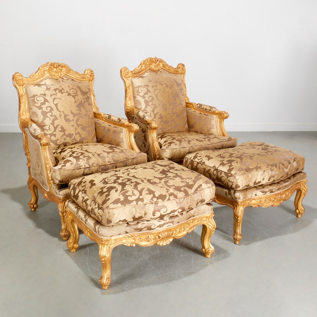 Pair Louis XV style giltwood bergeres and ottomans: Pair Louis XV style giltwood bergeres and ottomans, 20th c., of superior quality, richly carved frames with arched shell and floral carved crest, padded arms with acanthus terminals, loose cushion sea