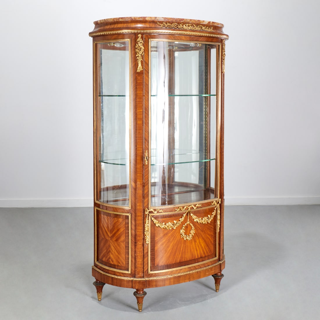 Louis XVI style bronze mounted parquetry vitrine: Louis XVI style bronze mounted parquetry vitrine, 19th c., Parisian quality, molded breccia marble top, over bow fronted glazed panel case with central door opening to interior glass shelves, on turne