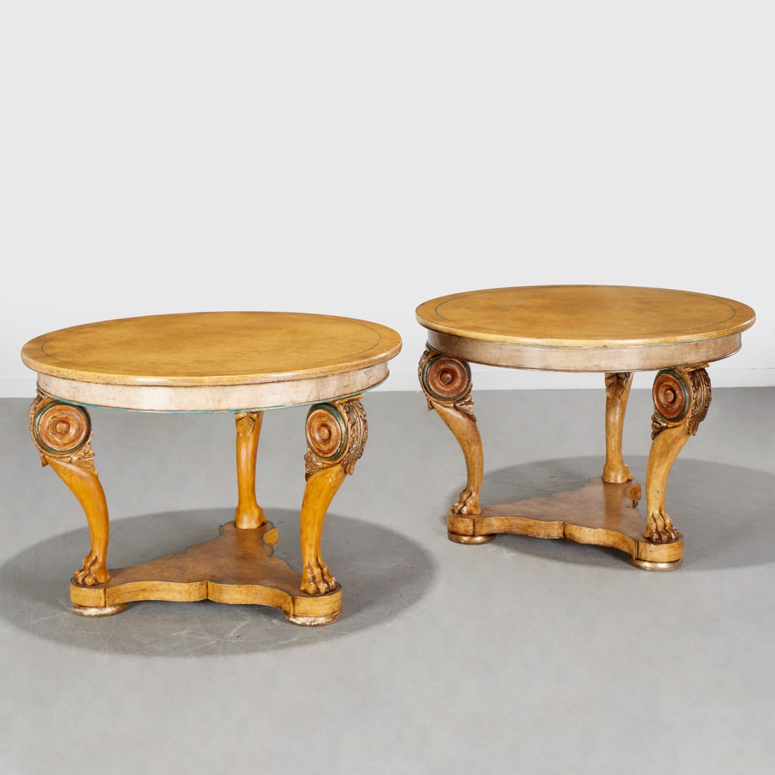 Pair Italian Neoclassical style center tables: Pair Italian Neoclassical style center tables, 20th c., Decorative Crafts Inc., paint decorated, round tops, over acanthus scroll carved cabriole legs and animal paw feet, on three-sided concave