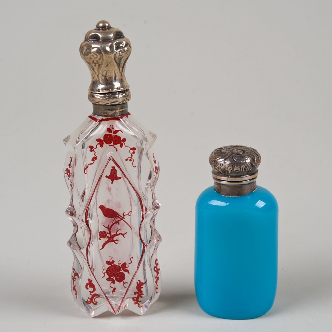(2) English and Continental silver scent bottles: (2) English and Continental silver scent bottles: 19th c., blue opaline and red flashed glass, larger: 5"l x 1.5"w, smaller: 2.75"l x 1.5"w