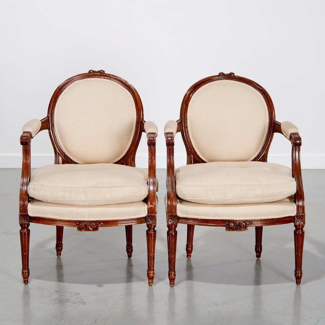 Pair Louis XVI upholstered fauteuils: Pair Louis XVI upholstered fauteuils, 18th/19th c., France, beechwood frames, rosette carved details, oatmeal upholstery, 34"h x 24"w x 21"d, 19"h (seat height)