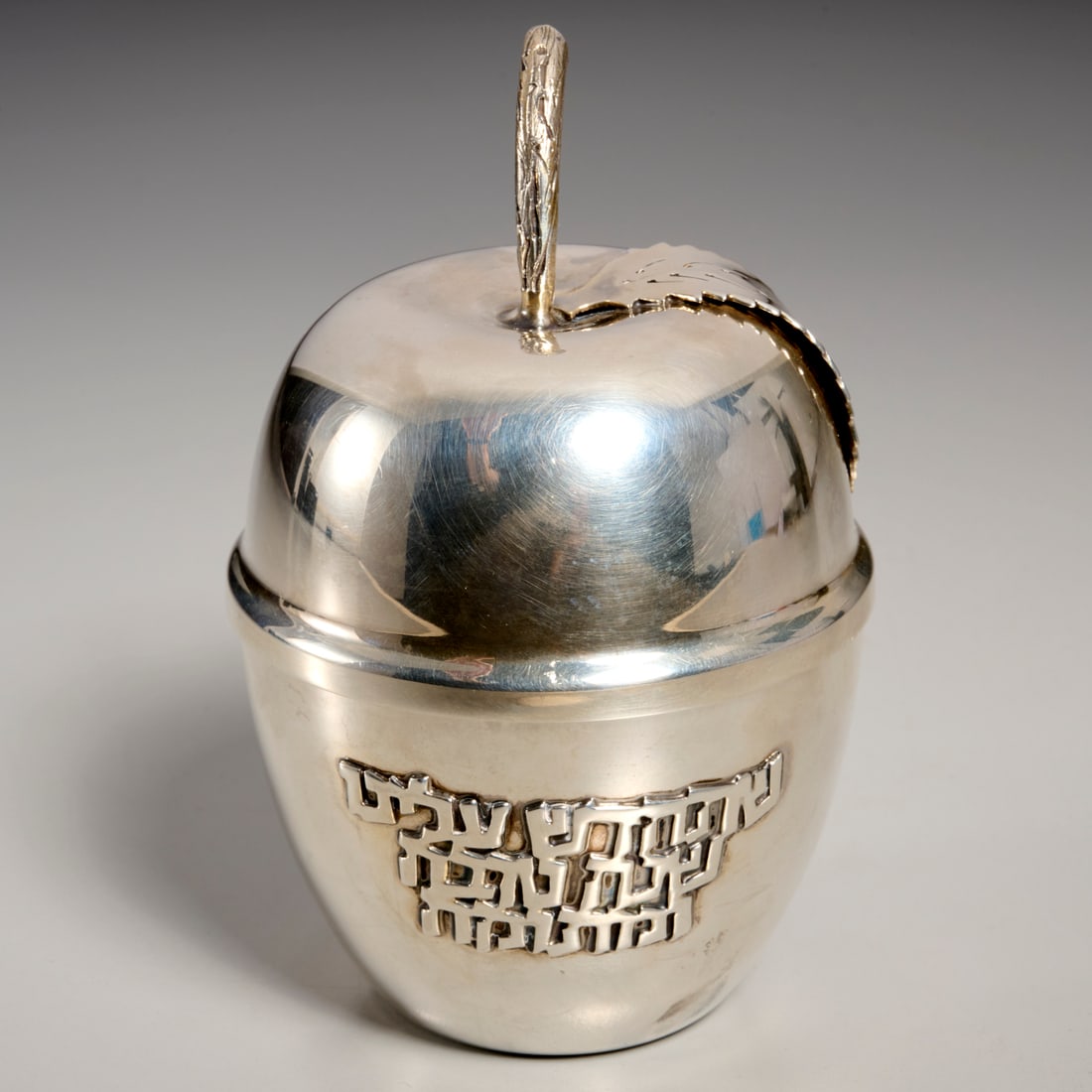 Bier sterling silver apple honey dish: Bier sterling silver apple honey dish, 20th c., Israel, apple form covered jar, with raised Hebrew inscription, glass insert, stamped "Made in Israel, Bier, Sterling" to underside, 4.5"h x 3"dia,