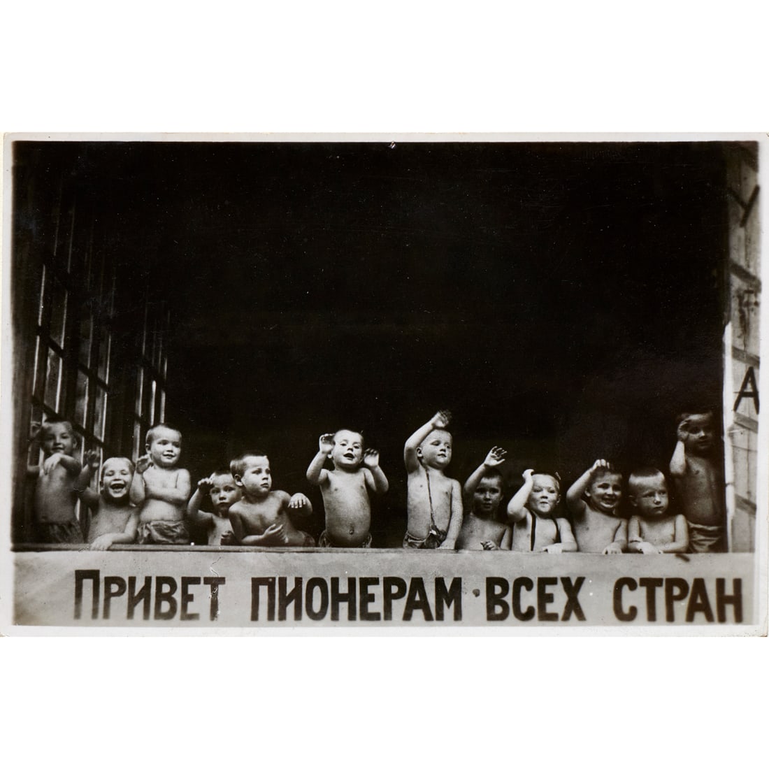 Vintage Russian photograph, 1931: Vintage Russian photograph, 1931, Glossy black and white photograph of children over the banner "Greetings to the Pioneers of All Countries", printed on verso is a postcard with the English caption