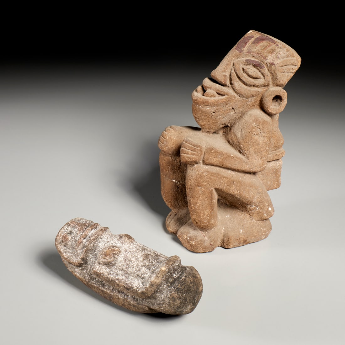 (2) Pre-Columbian style stone carvings: (2) Pre-Columbian style stone carvings, Incl. a seated Aztec style figure, 9.5"h x 5.25"l x 3.25"w; and a standing figure, of volcanic rock, possibly a pounding tool, 5.75"h x 1.75"w x 3"d
