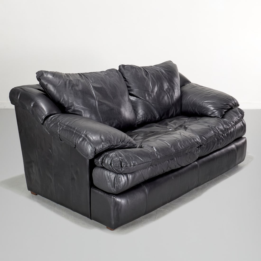 Robinson & Robinson black leather loveseat: Robinson & Robinson black leather loveseat, 20th/21st c., two cushion, with pillow back, unmarked, paper tag label under seat, 31.5"h x 69"w x 41"d Provenance: Property from a Prominent NYC Family Fou